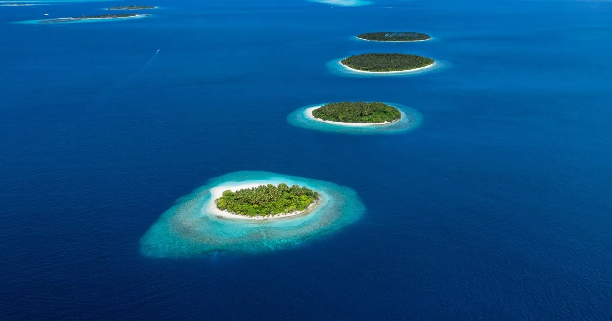 Aerial view of Maldives coral atolls and turquoise lagoons